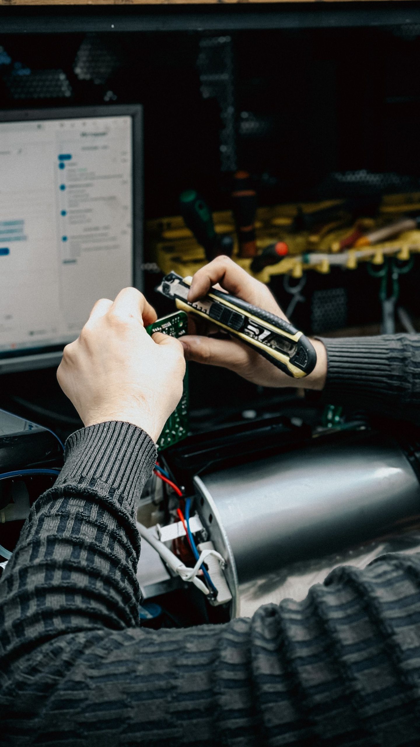 Technician repairing electronic components at a diagnostic workbench
