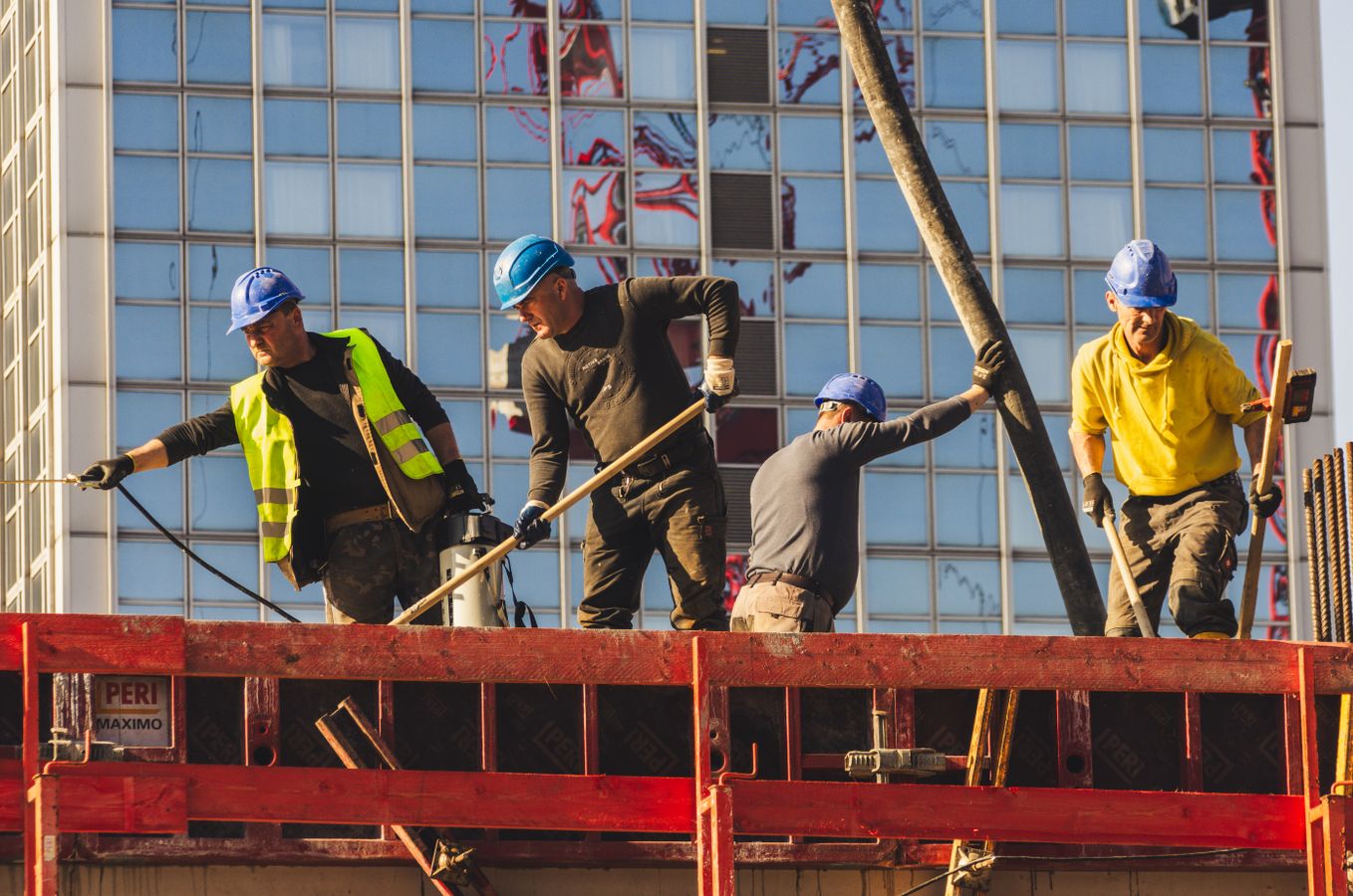Construction team in safety gear working on a high-rise building site