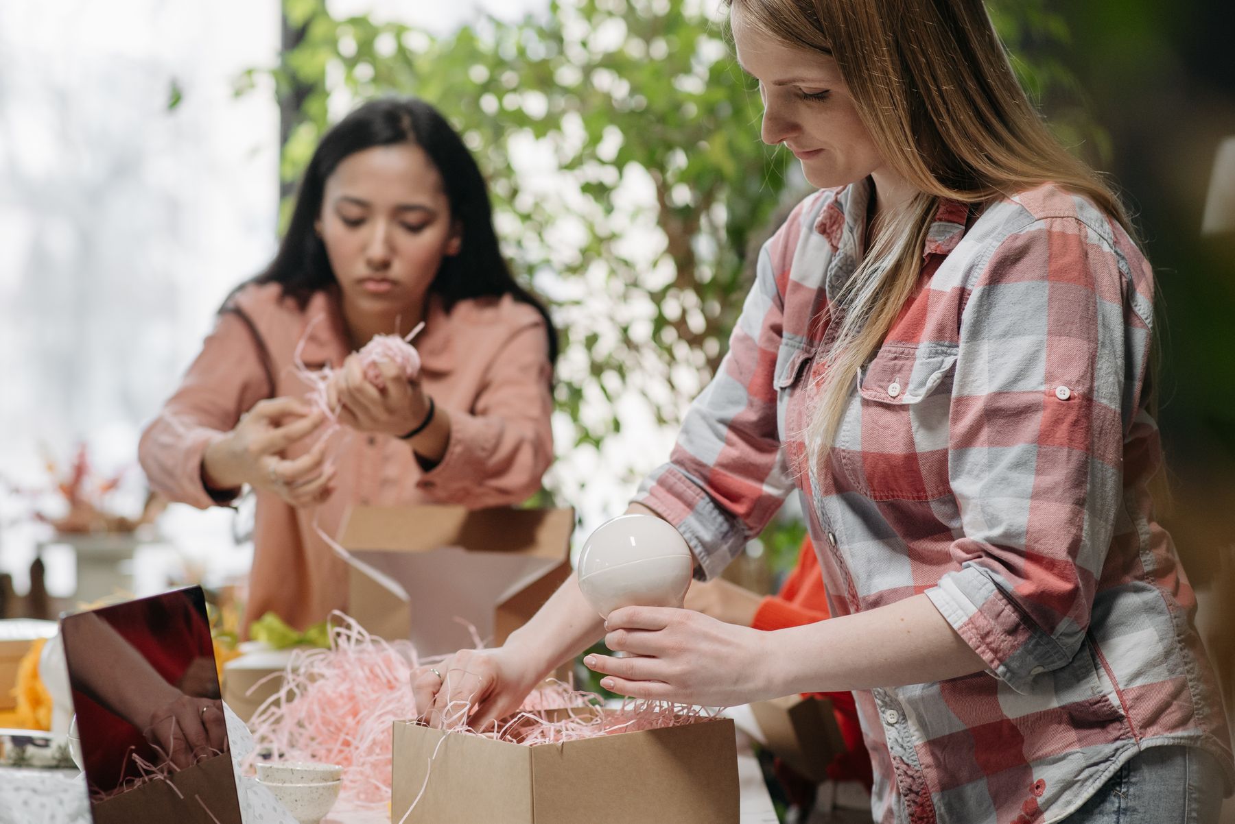 Small business team packing customer orders in cardboard boxes